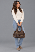 Femme dans une nouvelle pose avec le sac marron sur fond gris