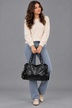 Femme dans une nouvelle pose avec le sac noir sur fond gris