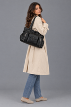 Femme en manteau beige et jean, en pied avec le sac noir