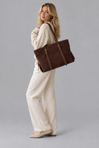 Femme en pied portant le sac marron sur fond gris