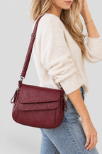 Femme portant le sac bordeaux sur fond gris clair