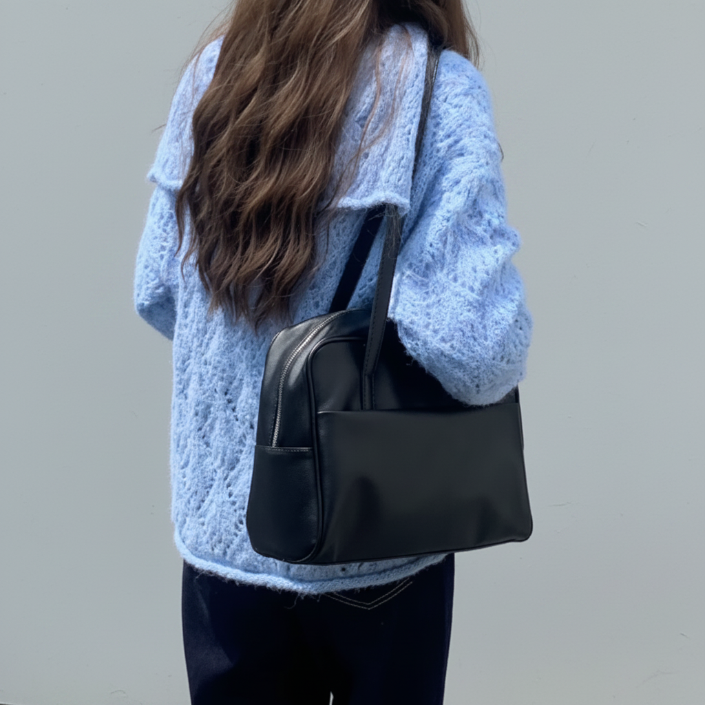 Femme sac noir dos fond gris clair