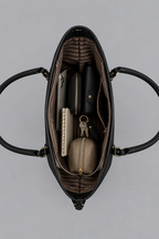 Intérieur du sac noir rempli des essentiels du quotidien