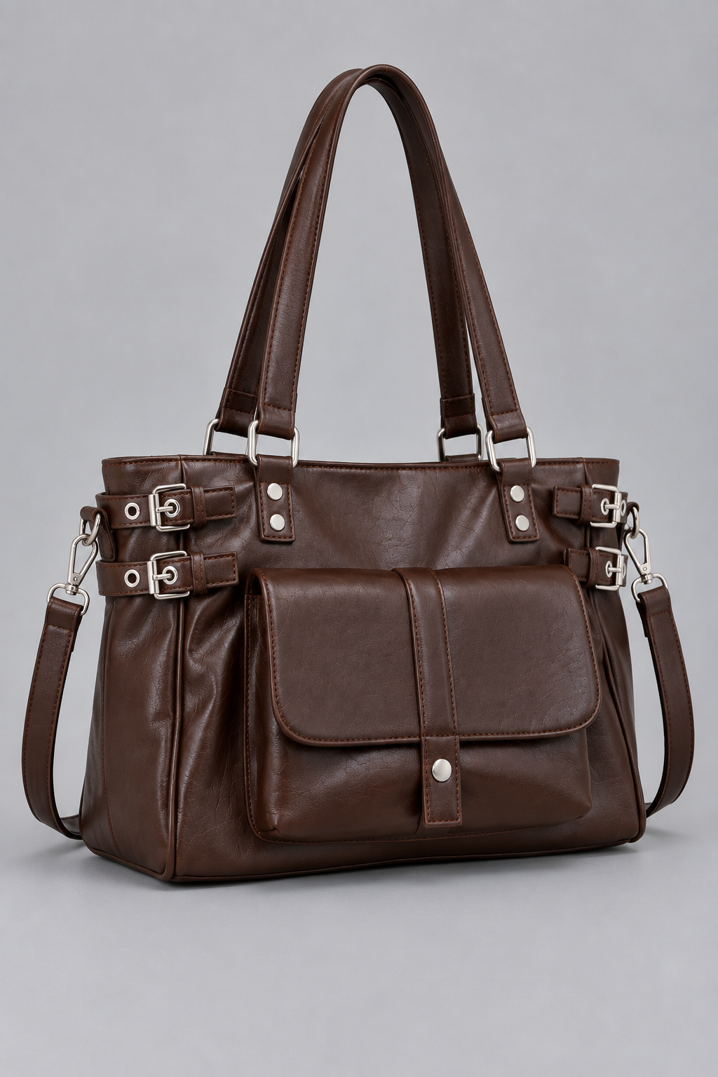 Sac marron à boucles argentées vu de côté sur fond gris