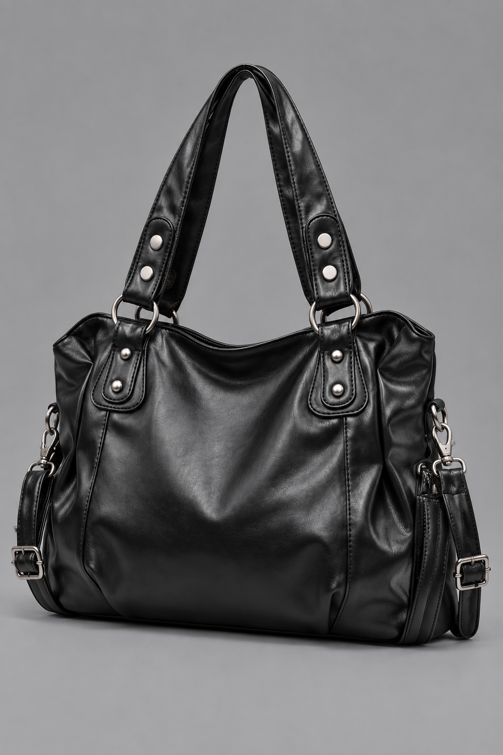 Sac noir à rivets argentés vu de côté sur fond gris